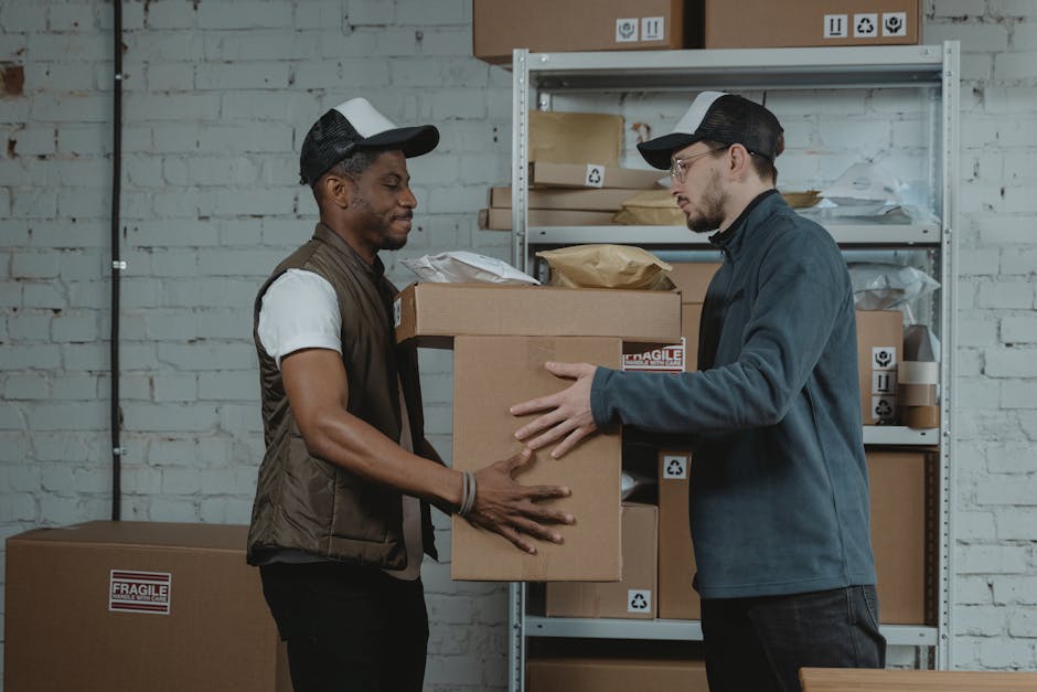 Two delivery workers handing over a package in a warehouse setting.